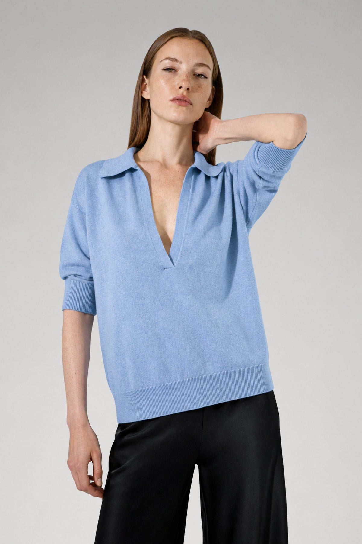 Pull Nina en laine mérinos bleu ciel col polo porté avec un pantalon noir, Huguet paris