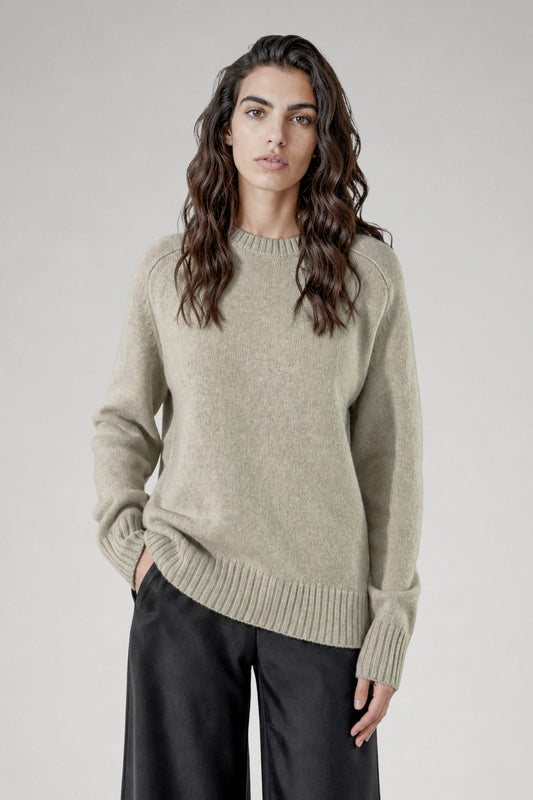 Pull col rond Cléo vert amande en laine mérinos porté avec pantalon gris, Huguet paris