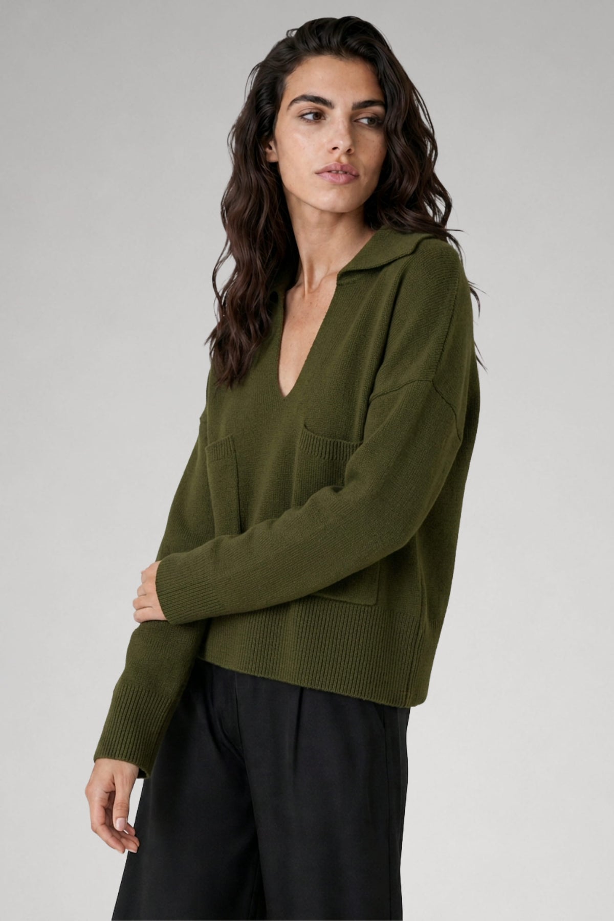 Pull Grace col v en laine mérinos vert avocat, porté avec pantalon gris, Huguet Paris